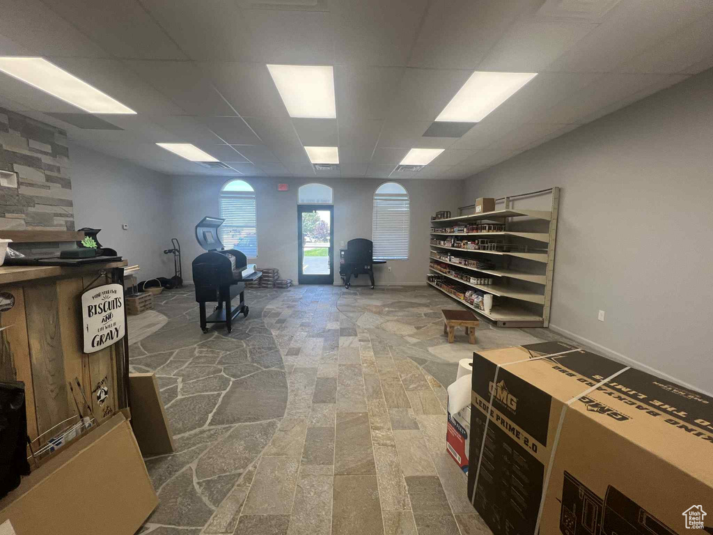 Office space with a paneled ceiling and stone finish floors