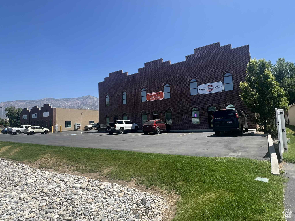 View of building exterior featuring uncovered parking and a mountain view