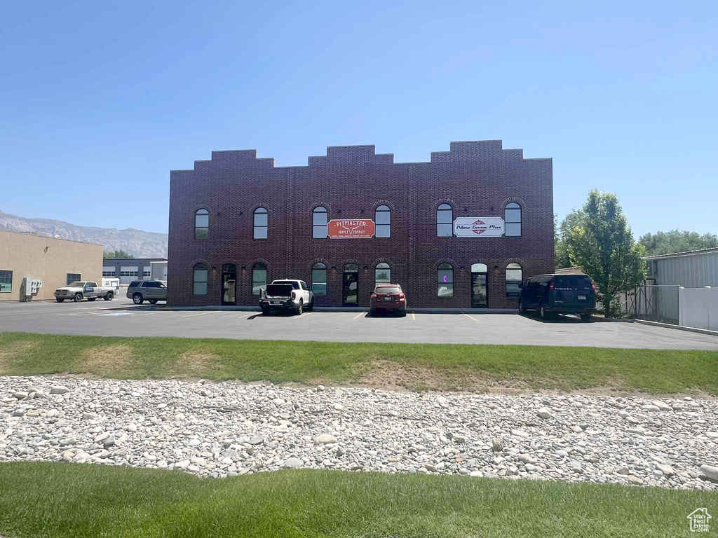 View of building exterior with uncovered parking and a mountain view