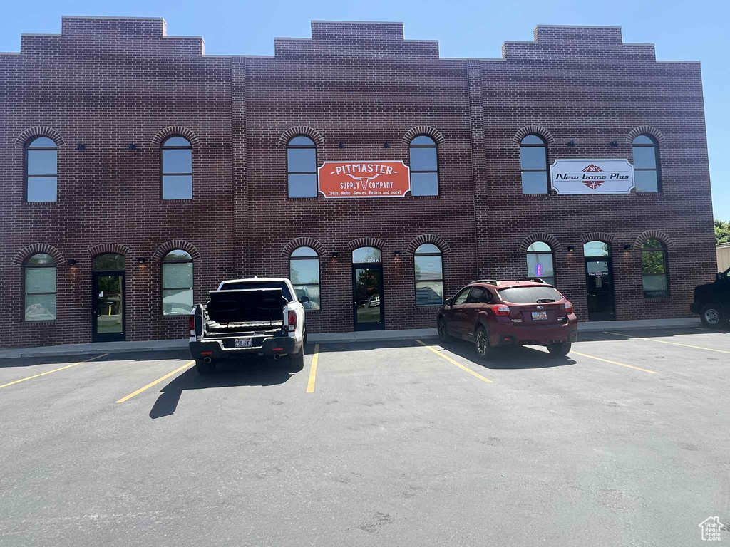 View of building exterior featuring uncovered parking