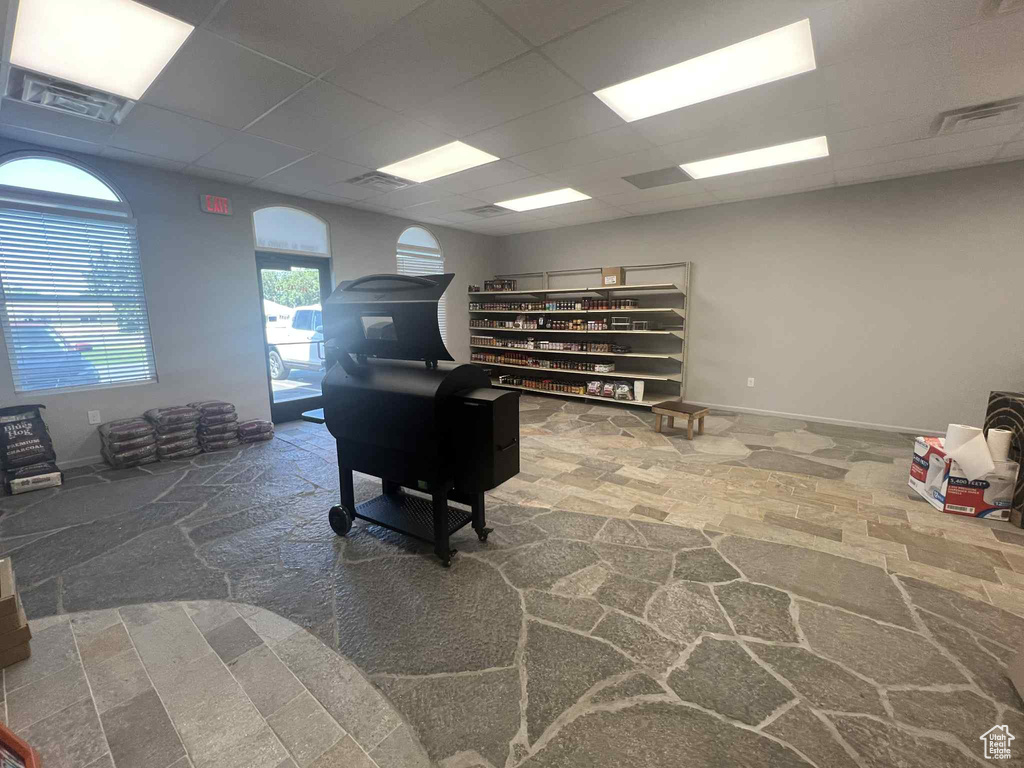 Interior space with a drop ceiling and stone finish flooring