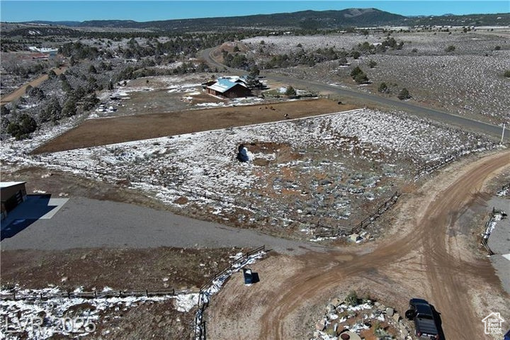 Aerial view of property and surrounding area featuring a mountainous background and rural landscape