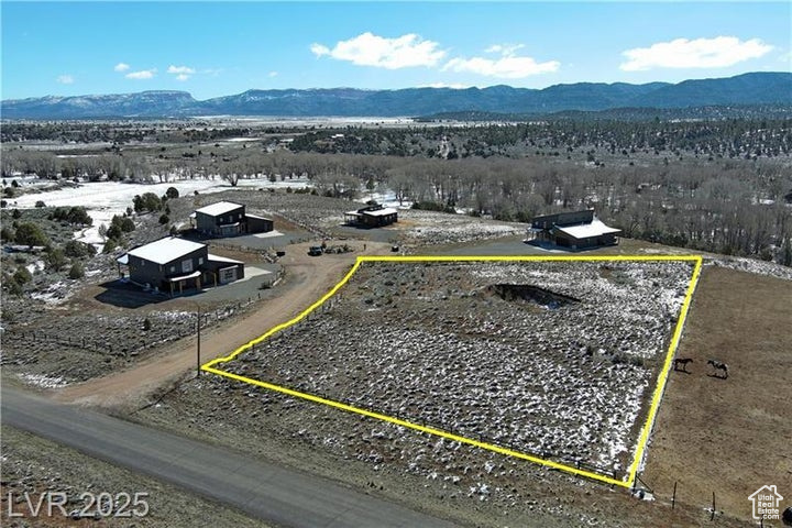Aerial overview of property's location featuring a mountain backdrop and property parcel outlined