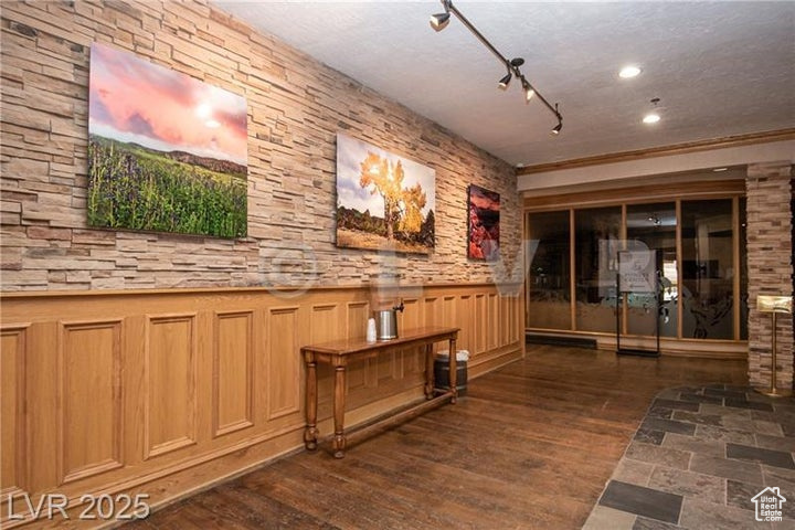 Hall featuring a wainscoted wall, wood finished floors, and recessed lighting