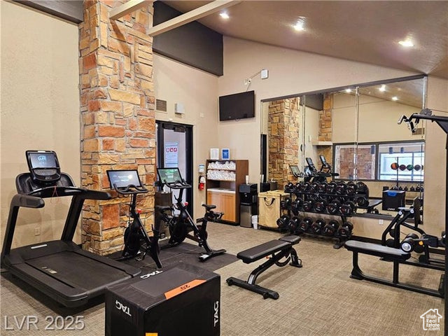 Exercise room featuring carpet flooring, high vaulted ceiling, and recessed lighting