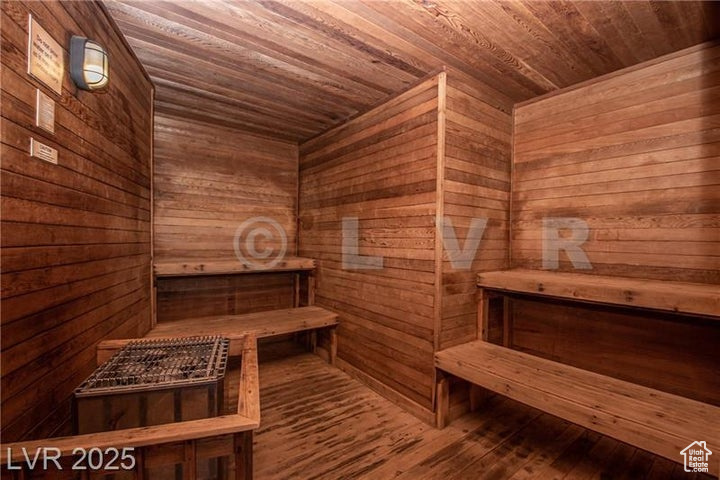 Sauna with wooden ceiling, wood walls, and wood finished floors