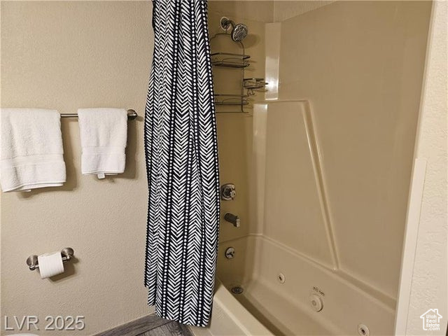 Full bath featuring shower / bath combo with shower curtain
