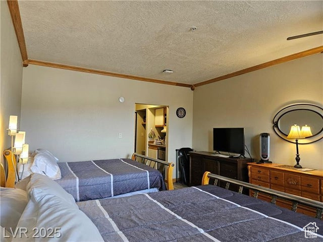Bedroom with crown molding and a textured ceiling