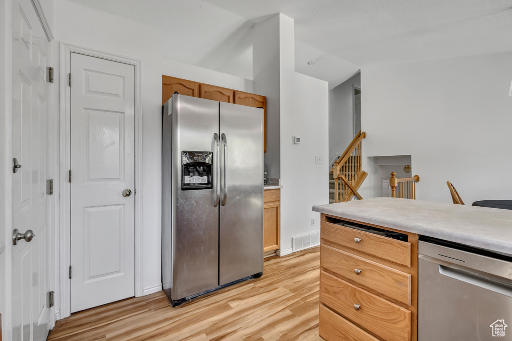 Kitchen with appliances with stainless steel finishes, light wood-style flooring, and light countertops
