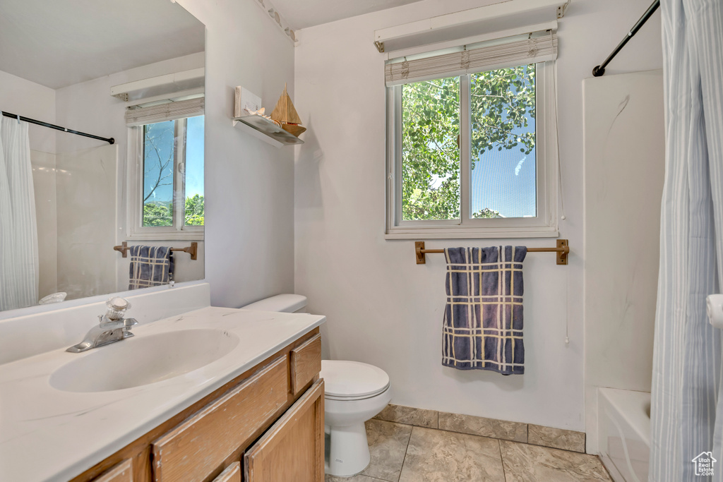 Full bathroom featuring plenty of natural light, vanity, and shower / bath combination with curtain