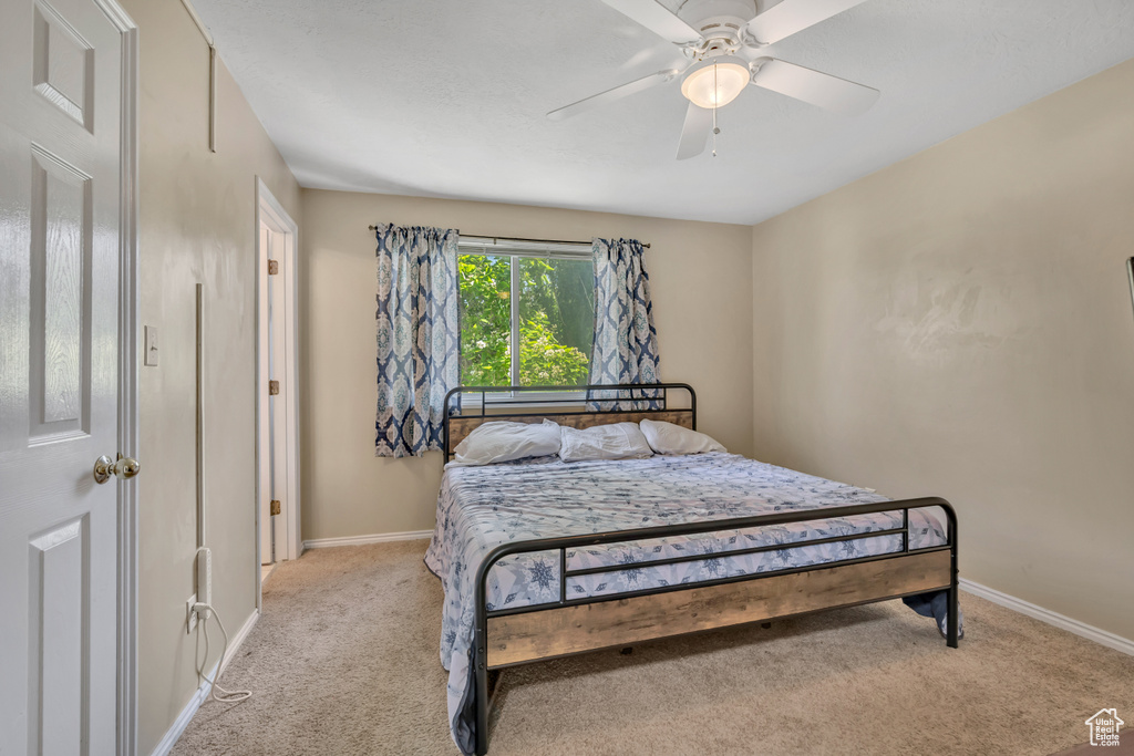 Bedroom with light carpet and a ceiling fan
