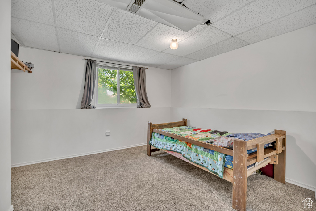 Bedroom featuring carpet flooring and a drop ceiling