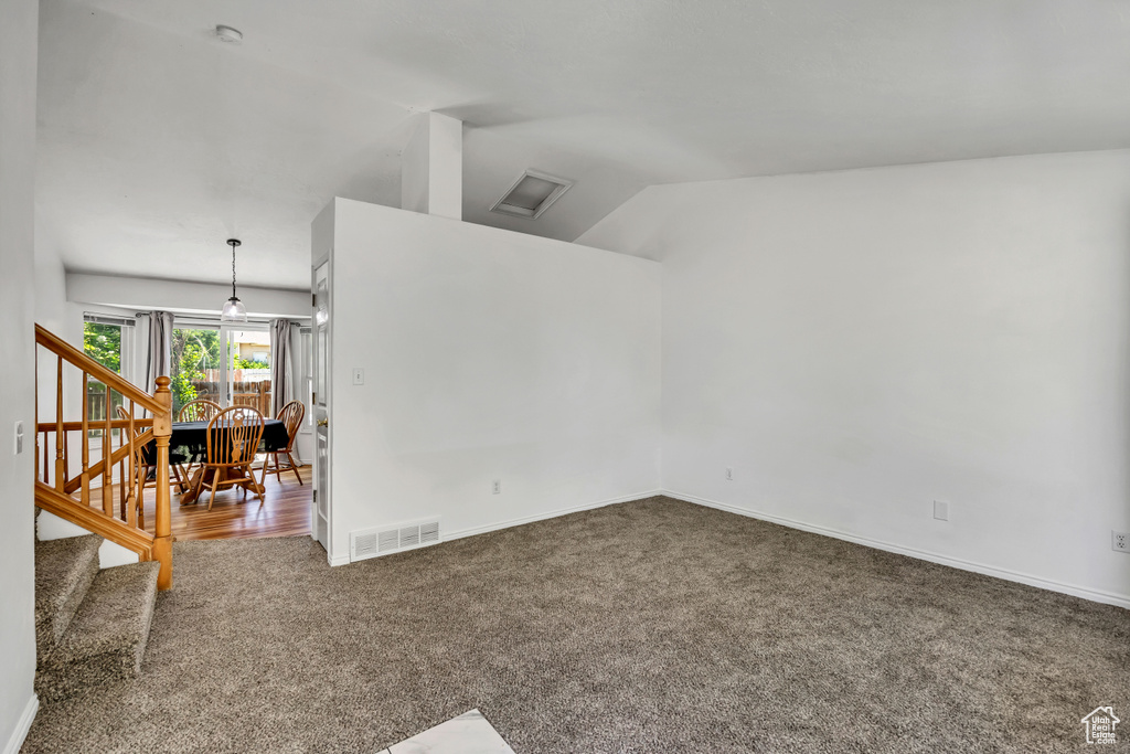 Spare room featuring carpet floors, lofted ceiling, stairs, and a smoke detector