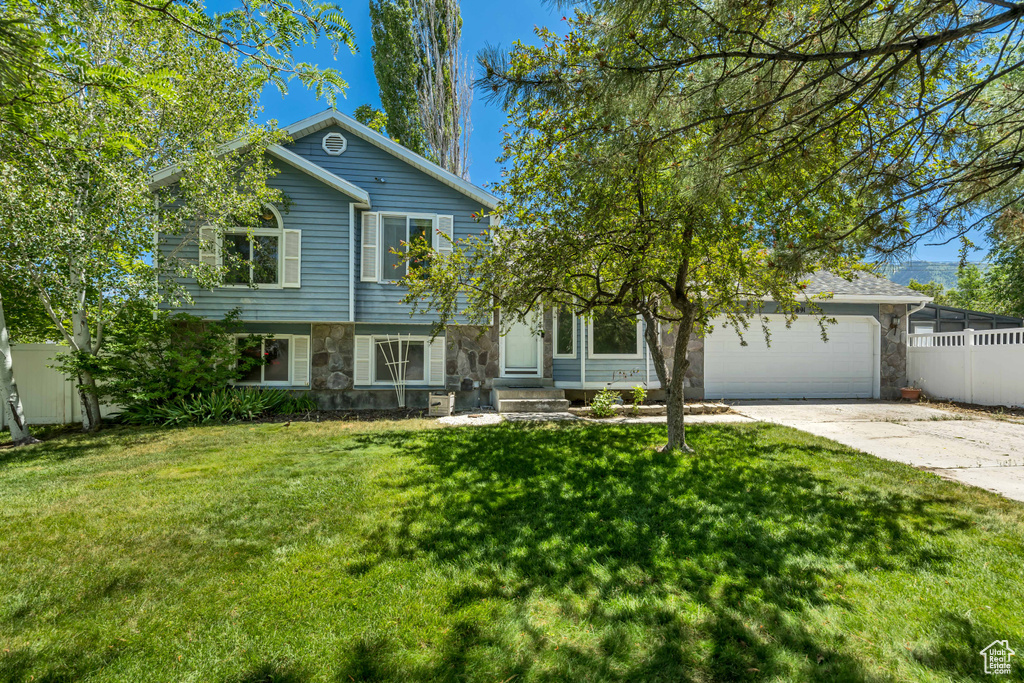 View of front facade with stone siding, concrete driveway, and a garage