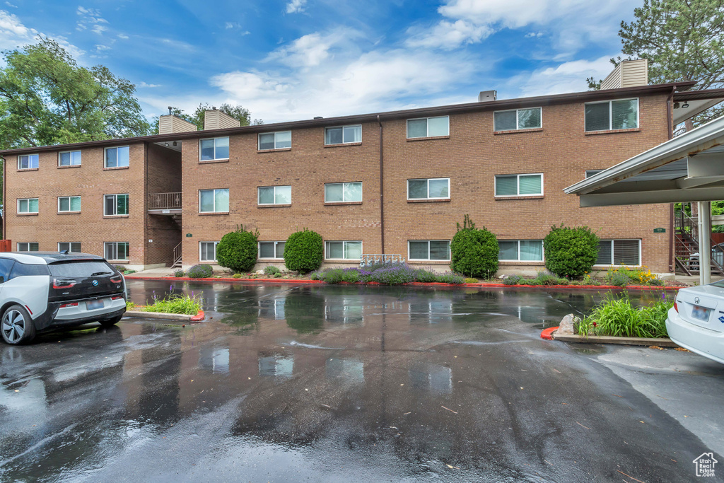 View of apartment building / complex with uncovered parking