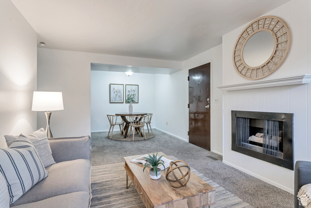 Living area featuring carpet flooring and a fireplace