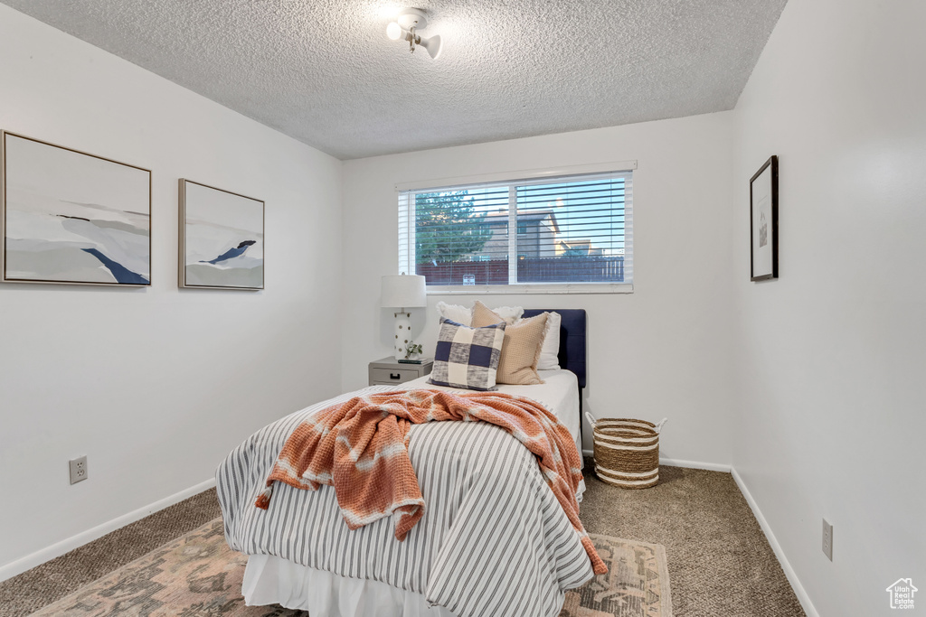 Bedroom featuring carpet flooring and a textured ceiling