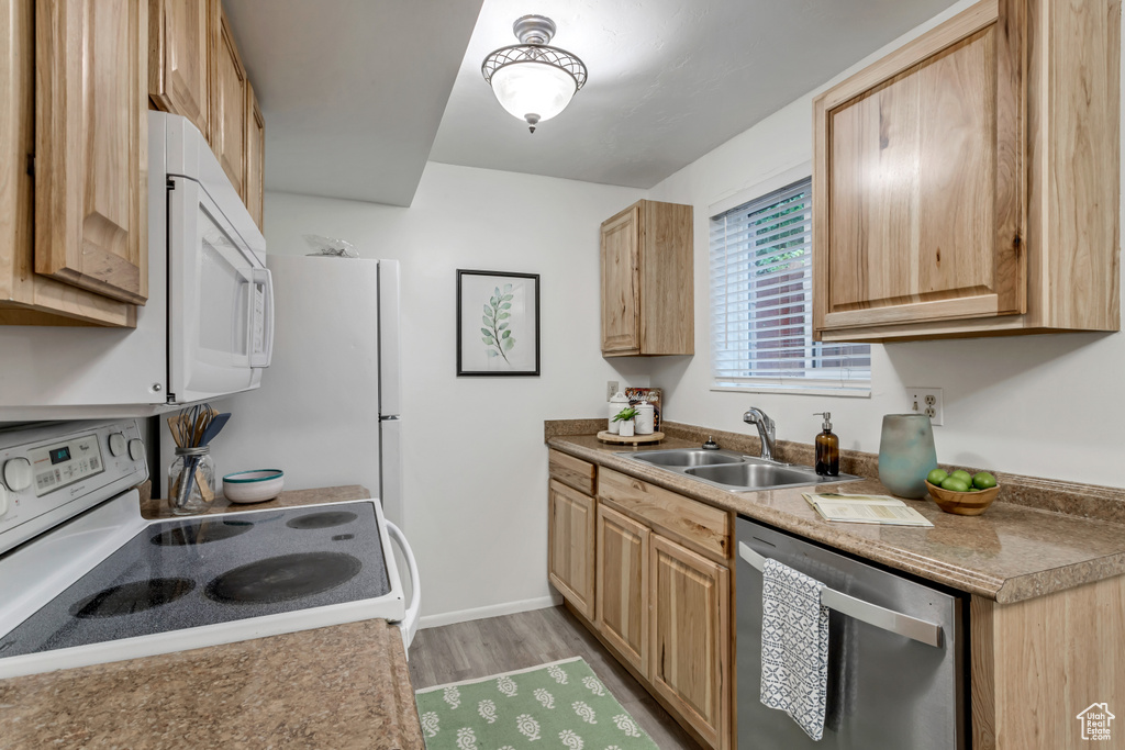 Kitchen featuring white appliances, light brown cabinets, and light wood-style floors