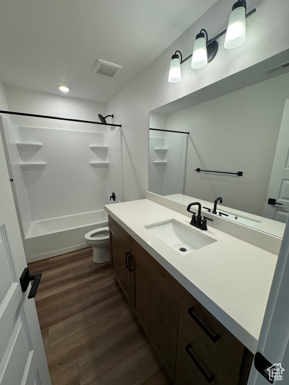 Bathroom featuring vanity, shower / washtub combination, wood finished floors, and recessed lighting