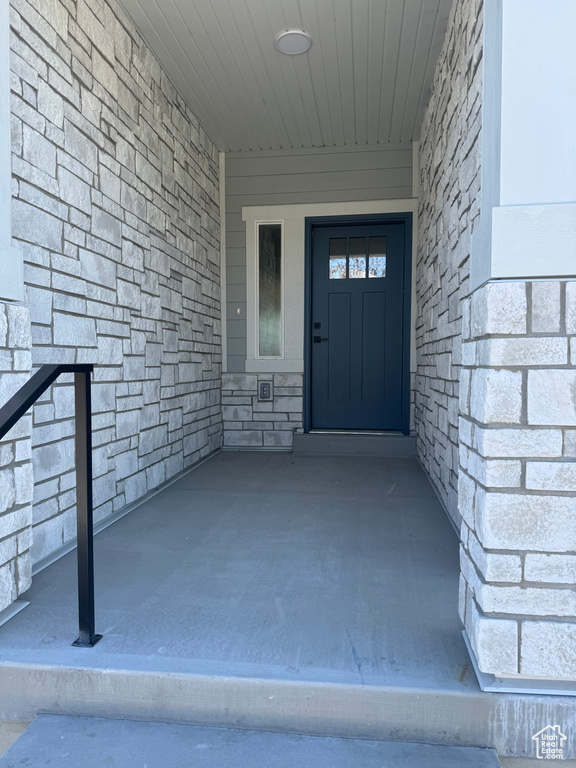 Doorway to property featuring stone siding
