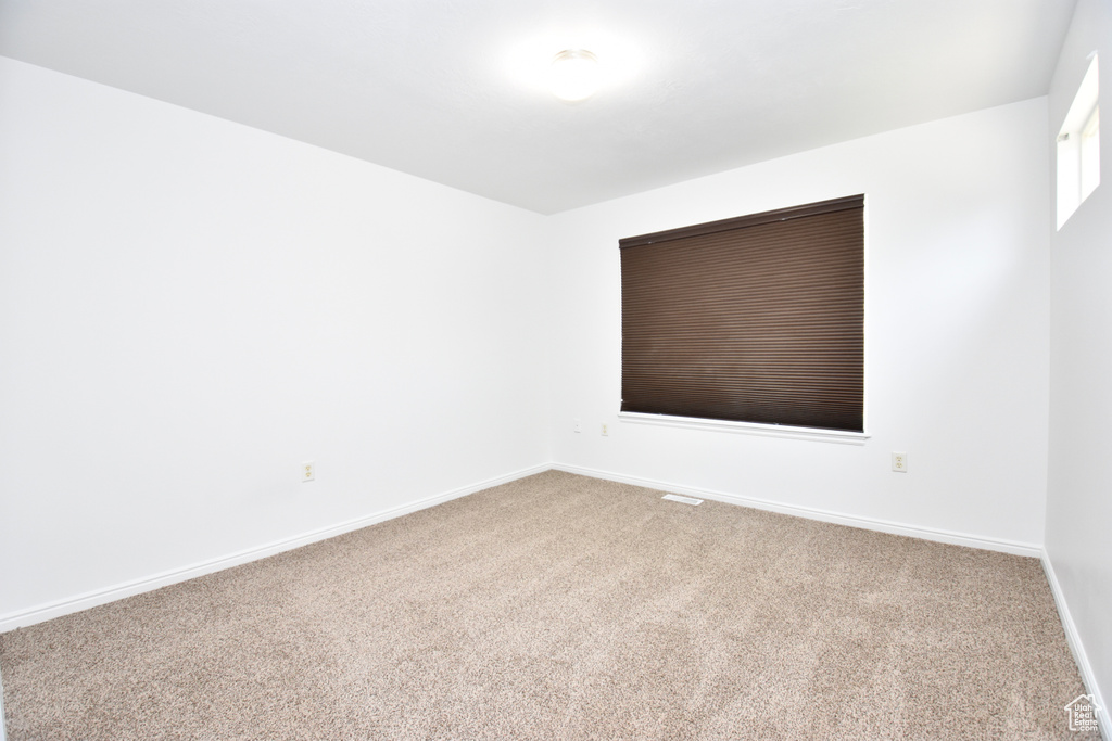 Carpeted empty room featuring baseboards