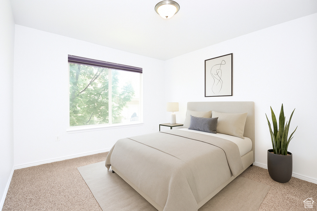 Bedroom featuring light carpet