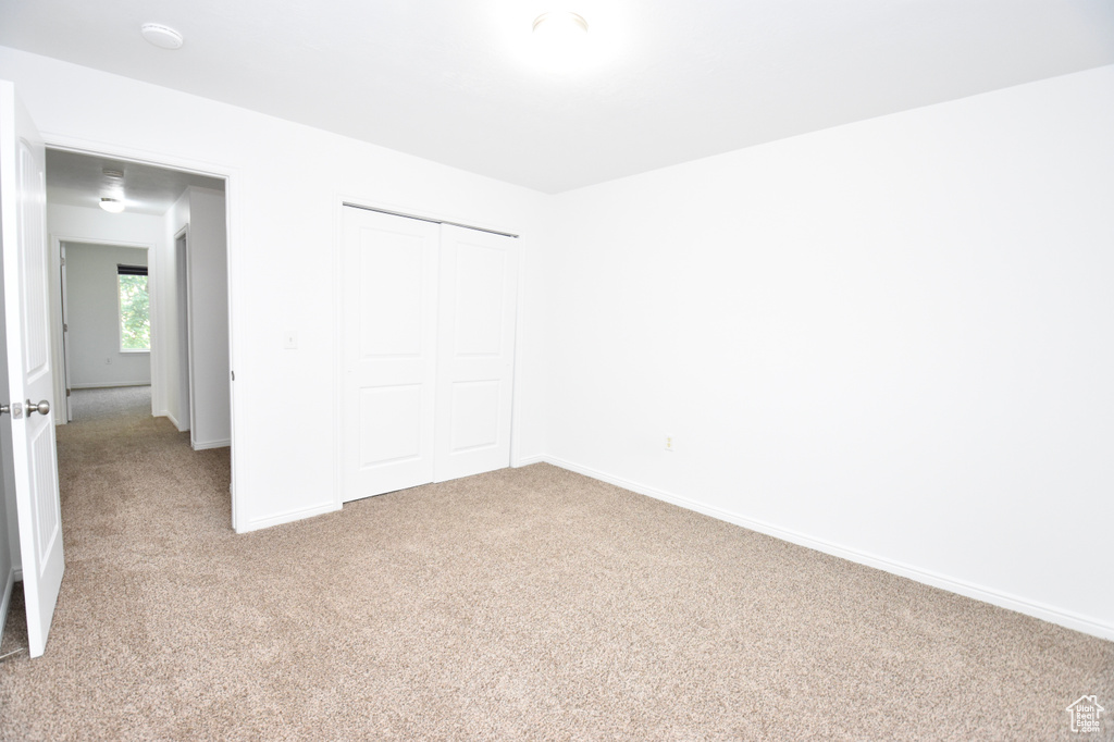 Unfurnished bedroom with carpet flooring and a closet
