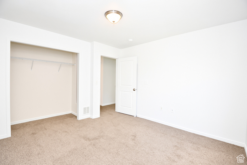 Unfurnished bedroom featuring carpet flooring and a closet