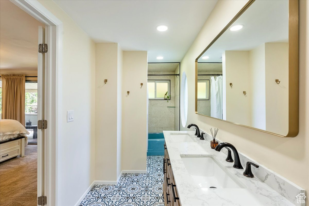 Bathroom with plenty of natural light, double vanity, recessed lighting, connected bathroom, and curtained shower
