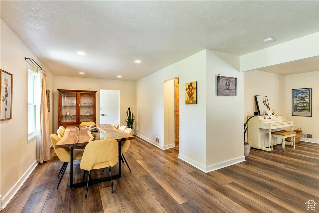 Dining space with dark wood finished floors and recessed lighting