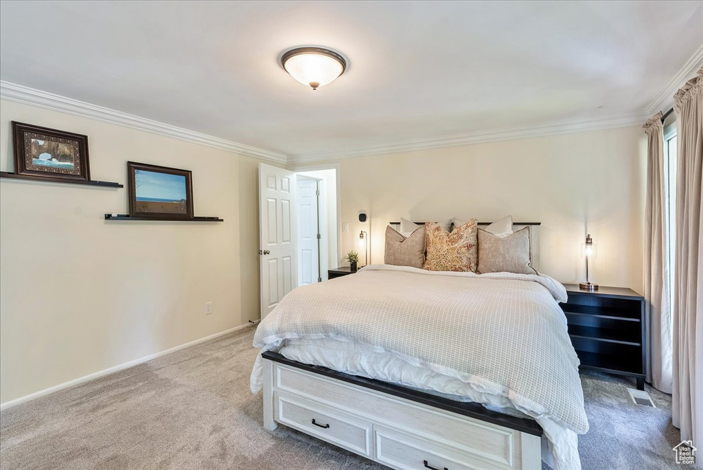 Bedroom featuring light colored carpet and ornamental molding