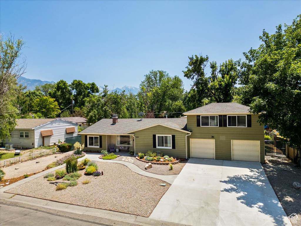 View of front of property featuring a garage, driveway, and a mountain view