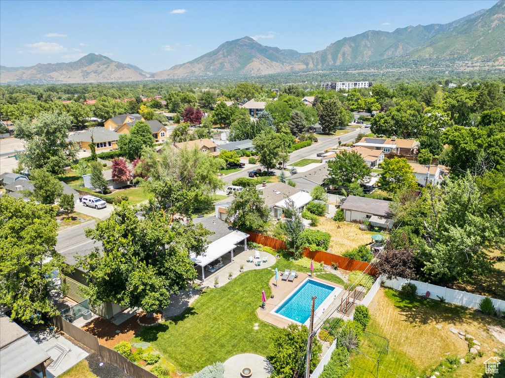 Aerial perspective of suburban area featuring a mountain backdrop and a pool area