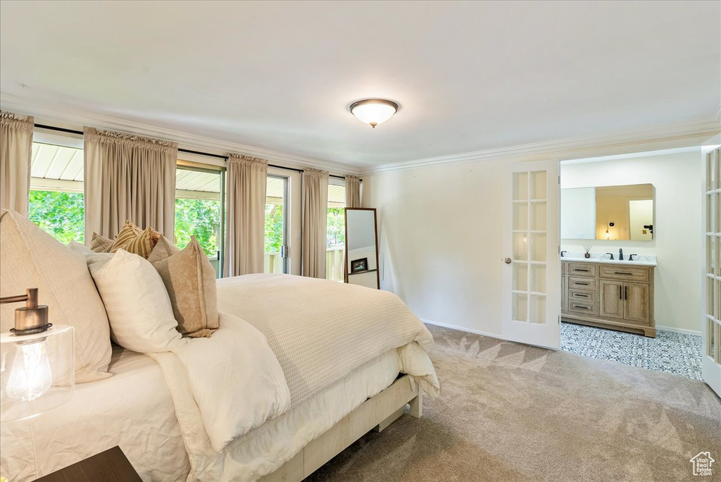 Bedroom with multiple windows, light carpet, crown molding, and french doors