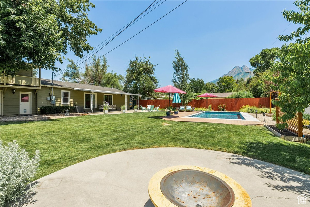 Fenced backyard featuring a patio area and a mountain view