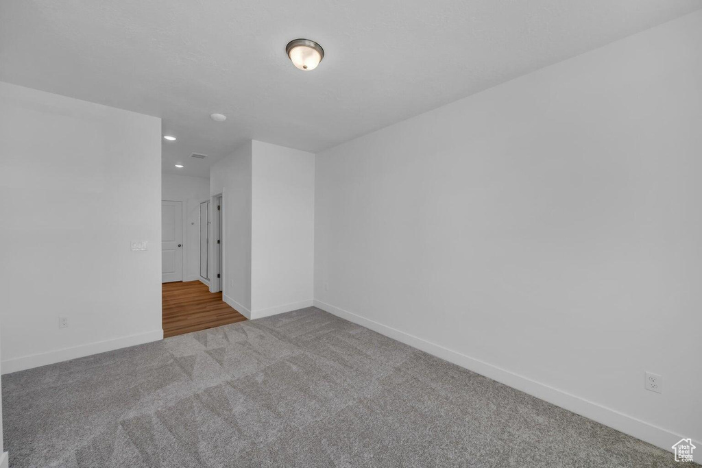 Carpeted spare room with baseboards and recessed lighting