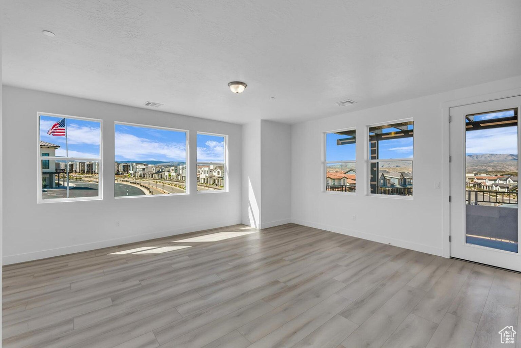 Spare room featuring wood finished floors and plenty of natural light