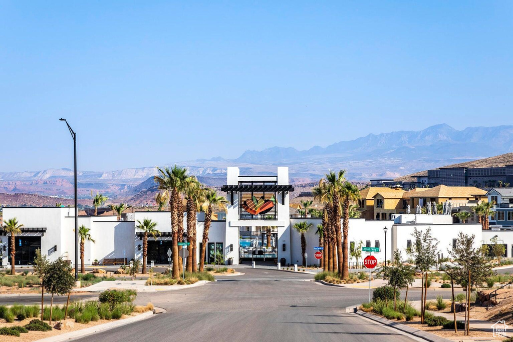 View of asphalt street with traffic signs, a mountain view, street lights, curbs, and a residential view