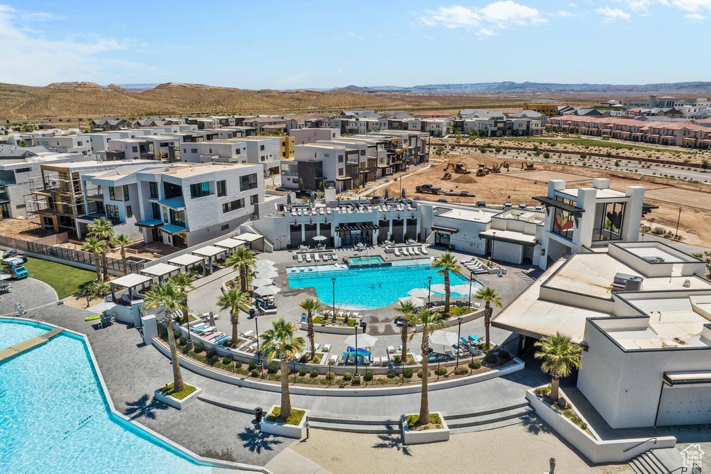 Aerial perspective of suburban area with a pool area and a mountain backdrop