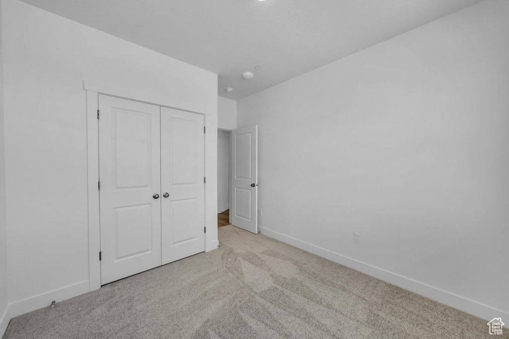 Unfurnished bedroom featuring carpet and a closet