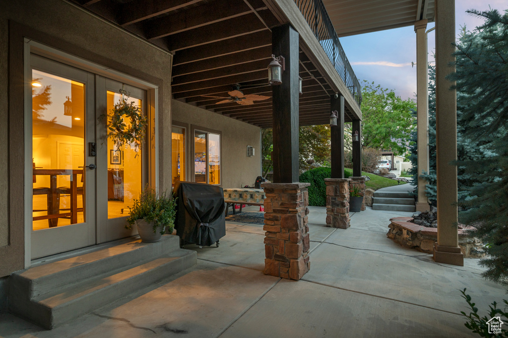 Patio terrace at dusk with french doors, a grill, and a ceiling fan