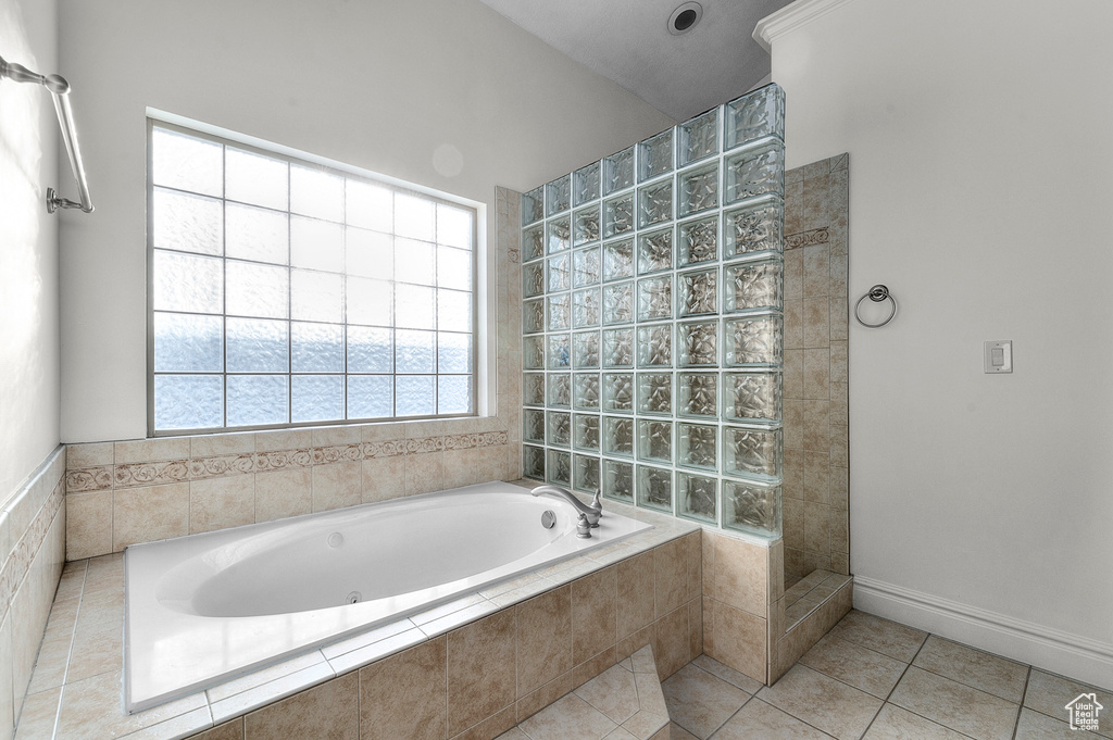 Bathroom featuring a whirlpool tub, tile patterned flooring, and a walk in shower