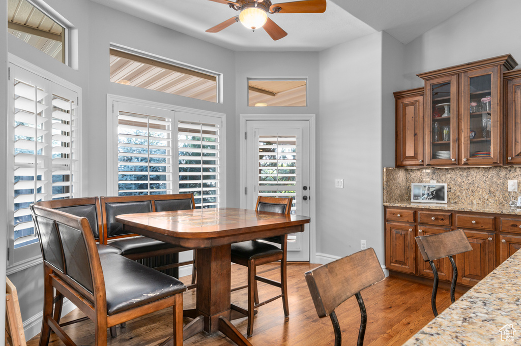 Dining area with ceiling fan and light wood-style flooring