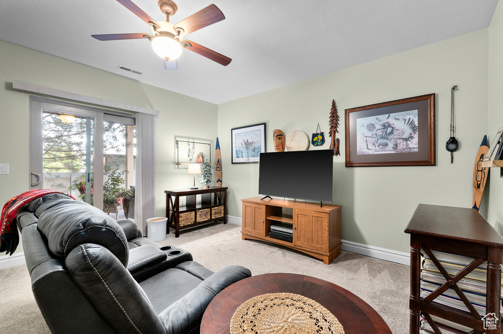 Living room featuring light carpet and a ceiling fan