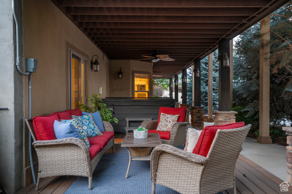 View of patio with outdoor lounge area, a hot tub, a ceiling fan, and a deck