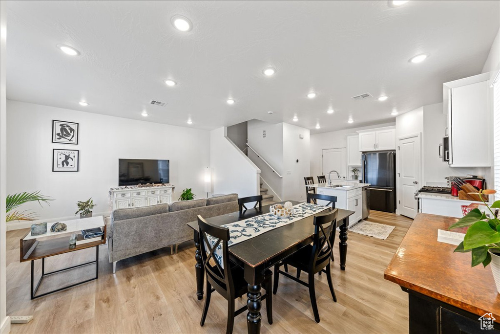 Dining area featuring stairway, light wood-style flooring, and recessed lighting
