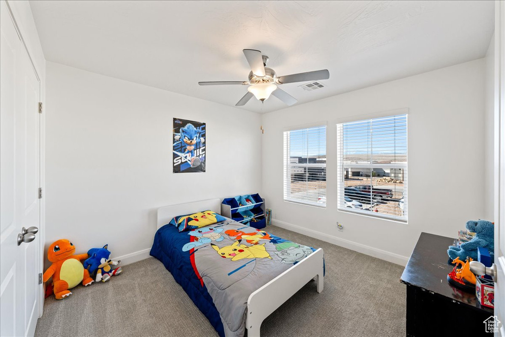 Carpeted bedroom with baseboards and ceiling fan