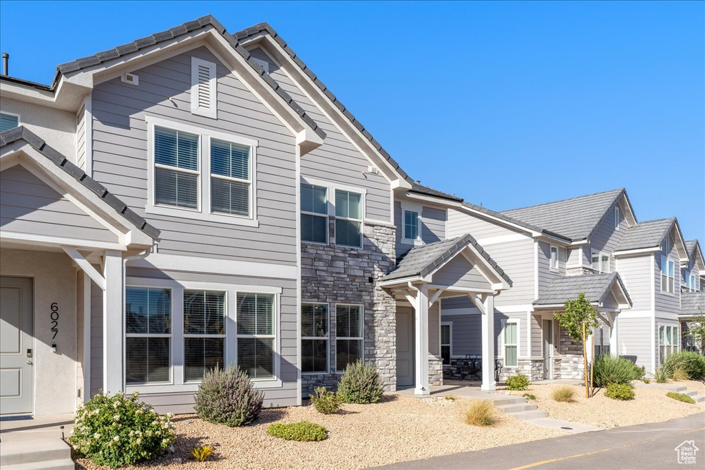 View of front of property featuring stone siding and covered porch