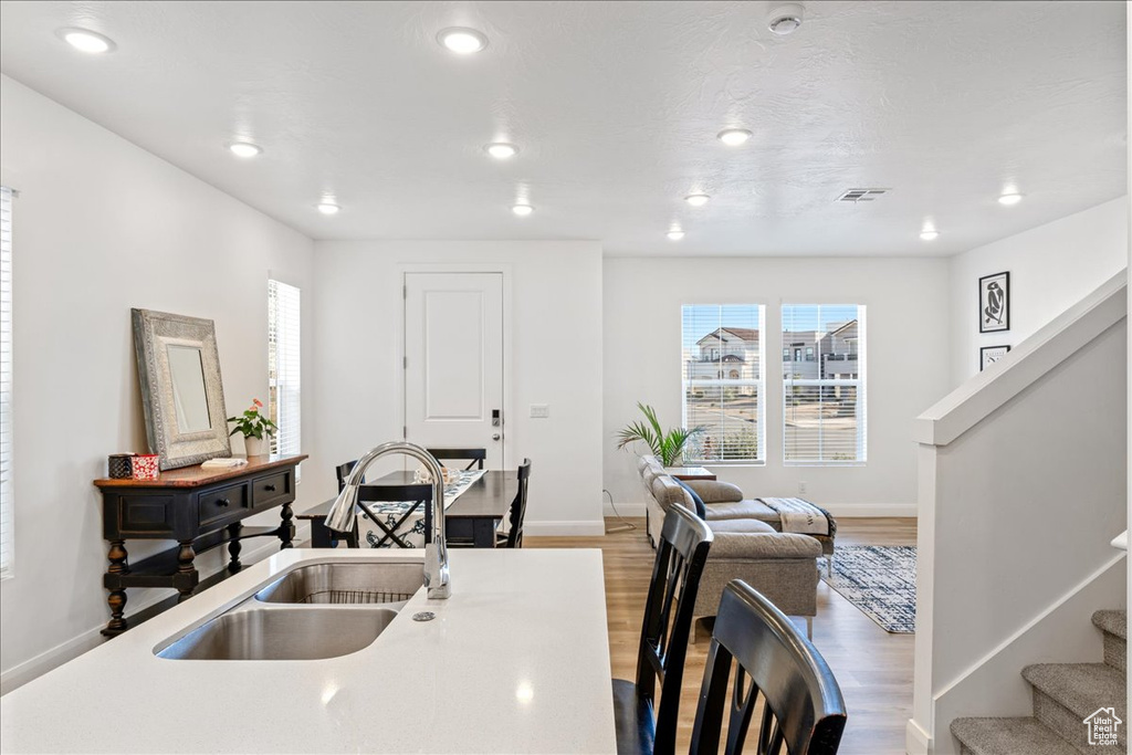 Kitchen with plenty of natural light, wood finished floors, recessed lighting, and light countertops