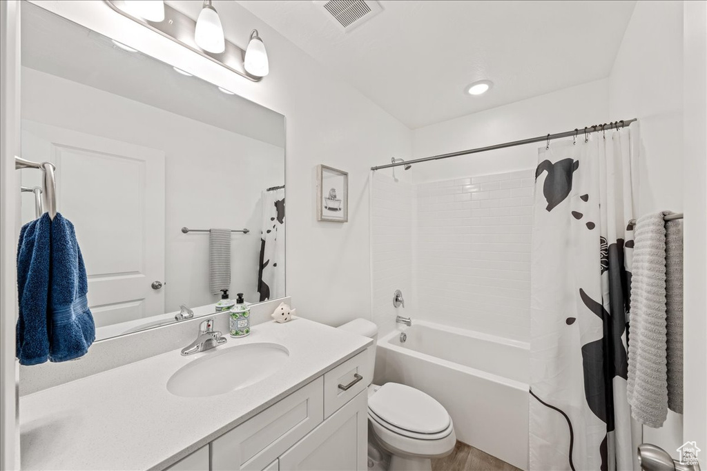 Bathroom featuring vanity and shower / bath combo with shower curtain